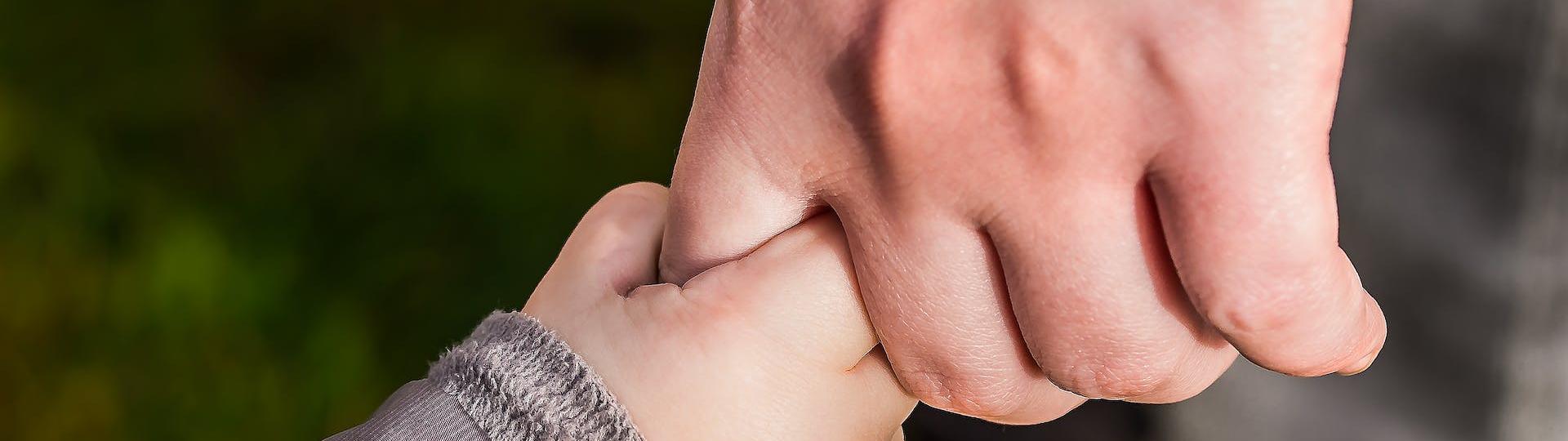 Enfant et adulte qui se tiennent la main