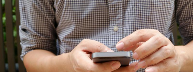 Main d'un homme sur son téléphone
