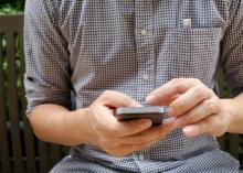 Main d'un homme sur son téléphone